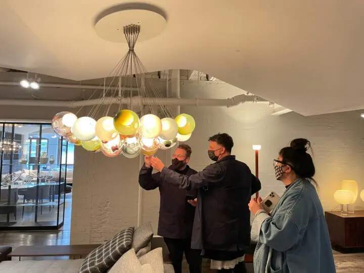 Michael Ellsworth, Randy Bishop, and Trish Chua examine a Bocci 28 Series chandelier in...