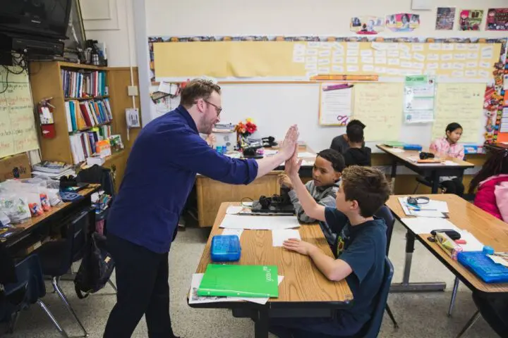 Michael Ellsworth high-fives a student in a lively classroom discussion for the Cooper ...