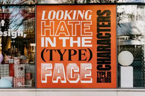 Storefront poster with bold text displaying Looking Hate in the (Type) Face Characters,...