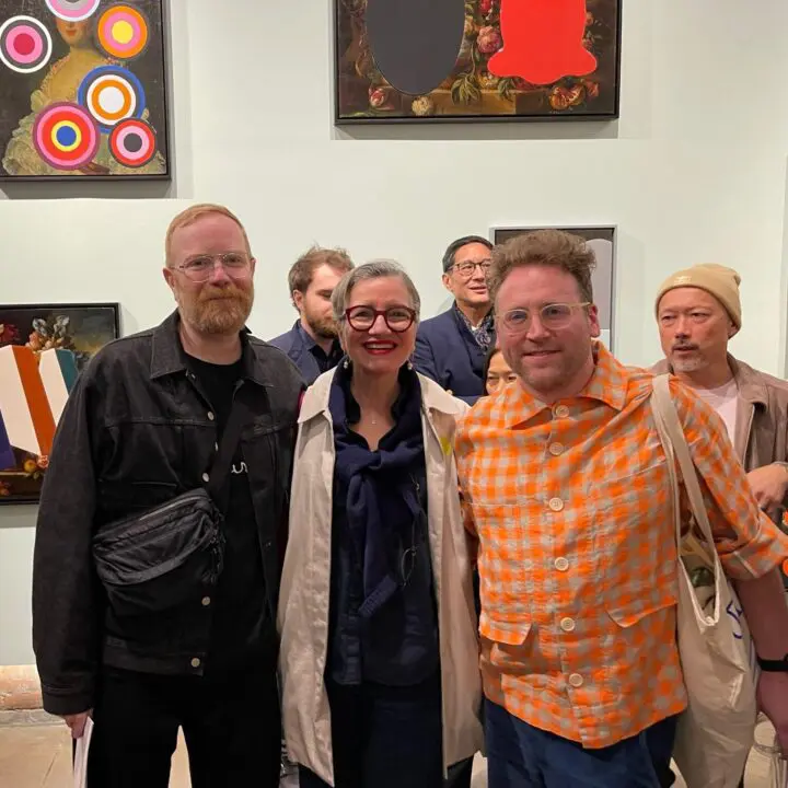 Group of people enjoying an art gallery, featuring colorful and abstract paintings on t...