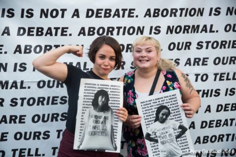 Pro-choice activists holding signs advocating for abortion rights against a backdrop reading Abortion is Normal, 2016.