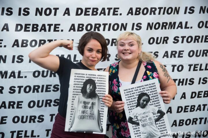 Pro-choice activists holding signs advocating for abortion rights against a backdrop re...