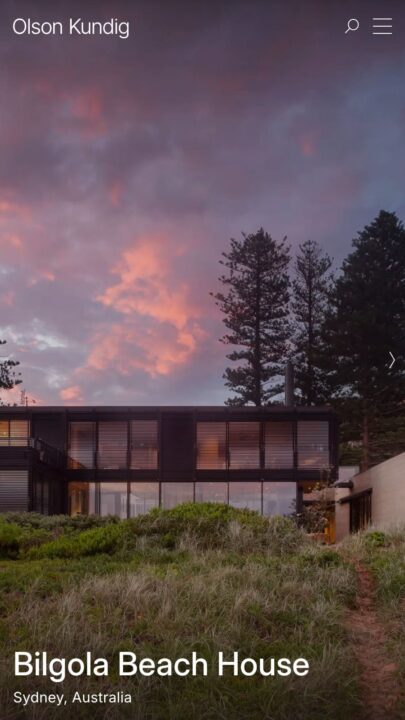 Modern Bilgola Beach House at sunset with lush greenery, glass facade, and tall trees. ...