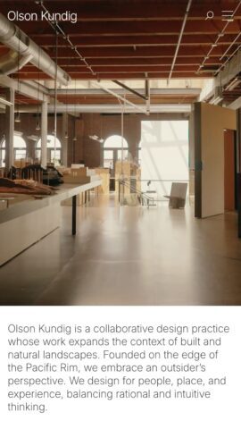 Modern office interior with industrial design, featuring wooden beams, large windows, and ample workspace for architectural projects.