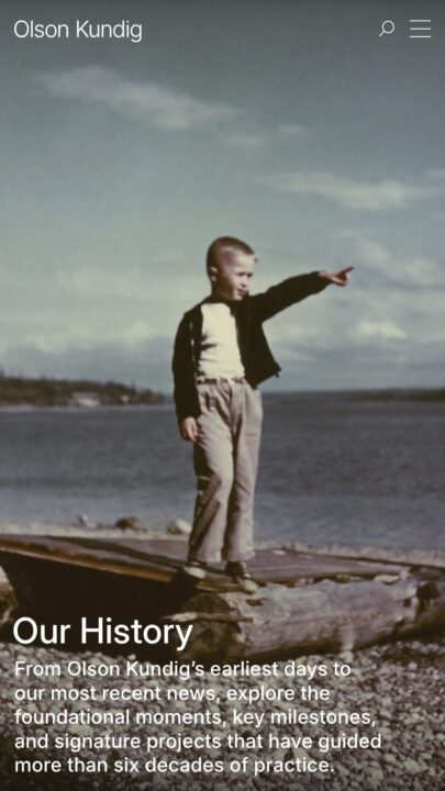 Young boy pointing towards sky by the sea, illustrating Olson Kundig's historical journ...