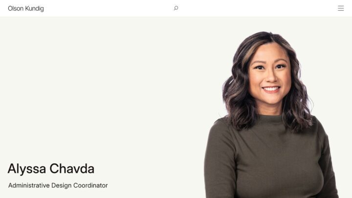 Smiling woman with shoulder-length hair in a green top, labeled as an Administrative De...