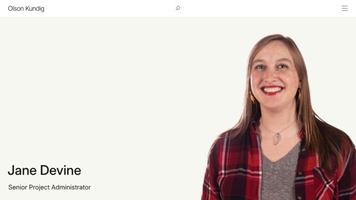 Smiling woman in a plaid shirt, profile page for Jane Devine, Senior Project Administra...