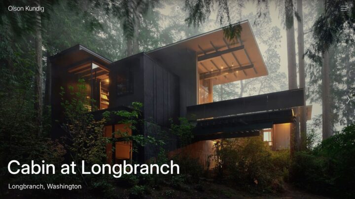 Modern cabin nestled in a forest, designed by Olson Kundig, with warm interior lighting...