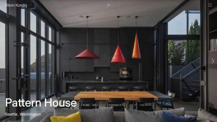 Modern kitchen in Seattle's Pattern House with dark cabinetry, colorful pendant lights,...