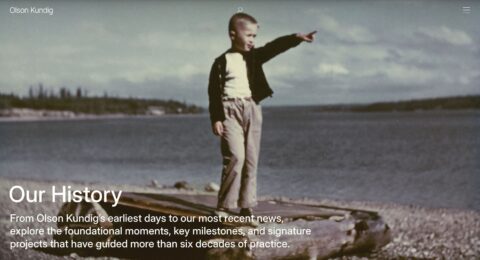 Young child pointing by a lake, symbolizing beginnings and exploration. Text reads Our History by Olson Kundig.