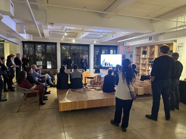 A group of people attentively listening to a presentation in a modern, well-lit office ...