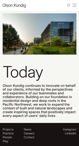 Modern glass building next to a trail with people jogging, showcasing Olson Kundig's architectural design.