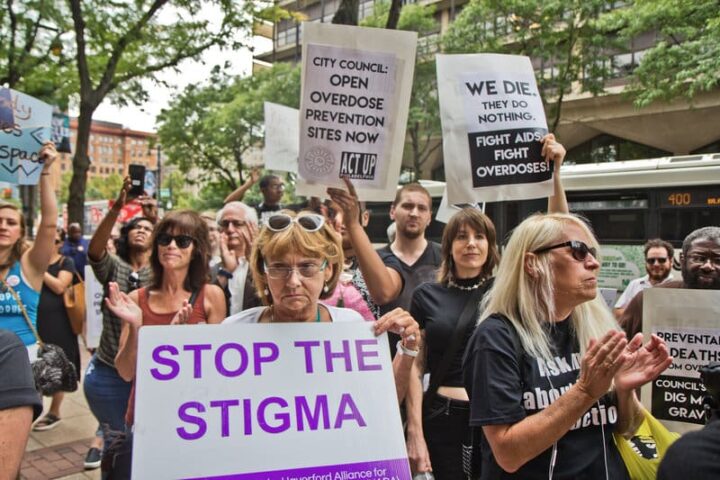 Protesters rally for overdose prevention, holding signs advocating to stop stigma and o...
