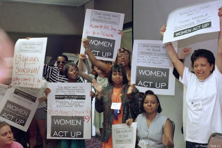 Women's rights rally with activists holding WOMEN ACT UP signs, advocating for health a...