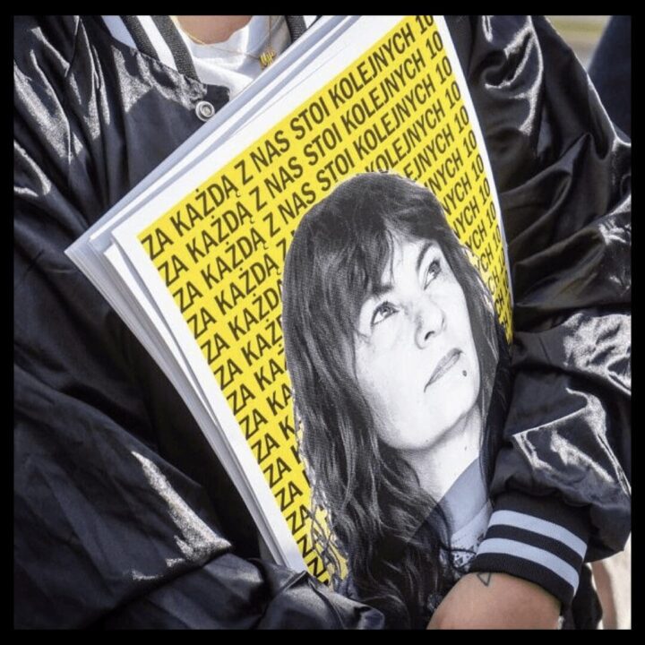 Person holding a book with a black-and-white portrait on the cover and repetitive yello...