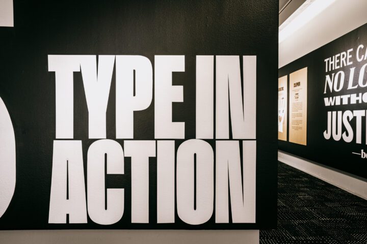 Large white text Type in Action on black wall, showcasing bold typography in a modern h...
