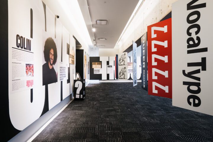 Exhibit showcasing social justice messages and typography in a modern museum hallway.