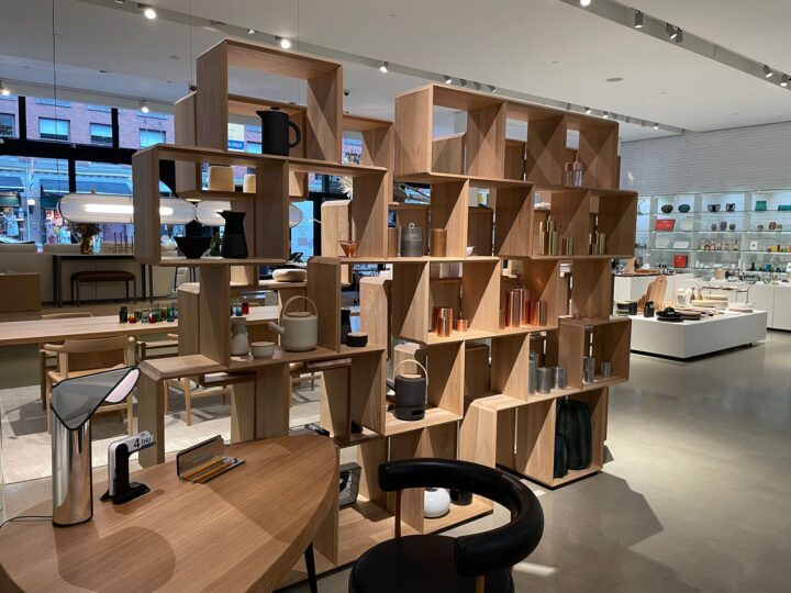 Modern interior store with wooden shelves displaying home décor items, featuring styli...