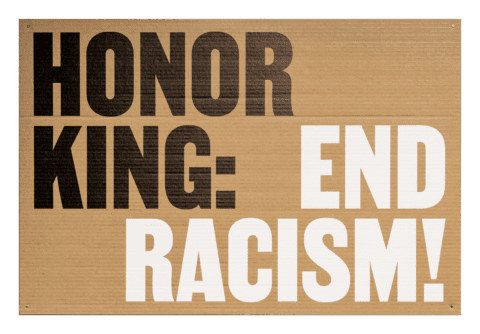 Protest sign with 'Honor King: End Racism!' in bold letters on corrugated cardboard background, advocating for social equality. Using Martin font by Vocal Type