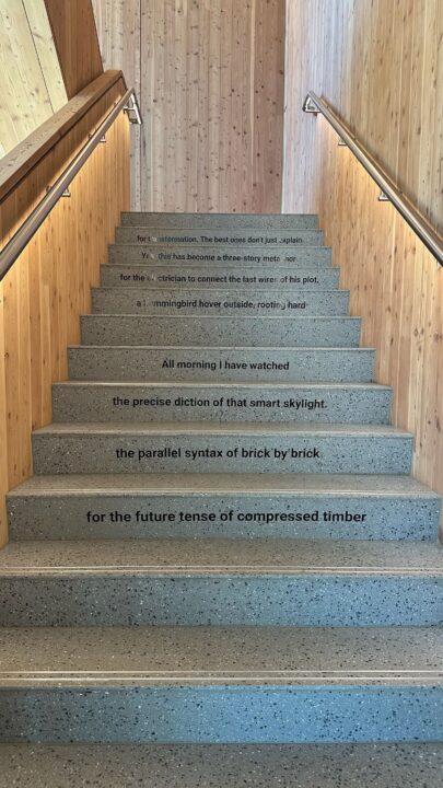 Concrete stairs with wooden walls, featuring poetic text on each step, leading upwards ...