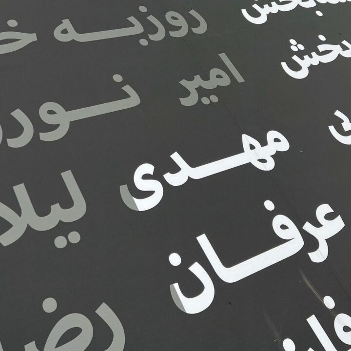 White Arabic script on a dark surface, featuring prominent names and decorative typogra...