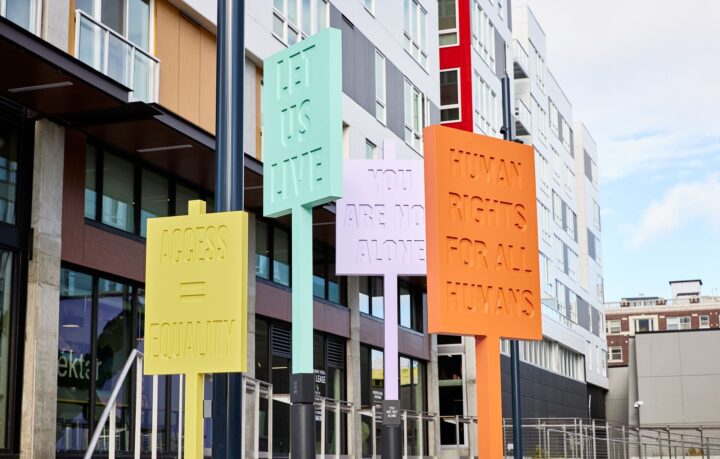 Colorful signs outside a modern building advocate human rights, equality, and unity wit...