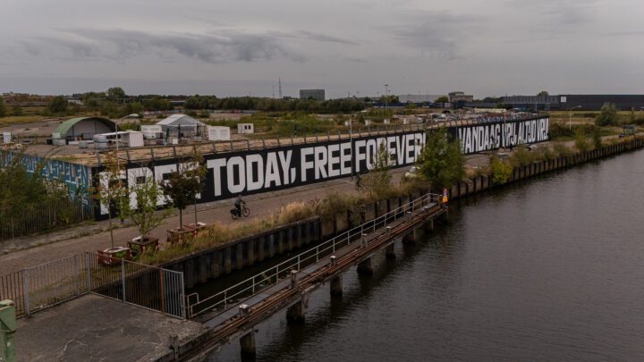 Large mural by a waterfront reads Free Today, Free Forever in bold letters, surrounded ...
